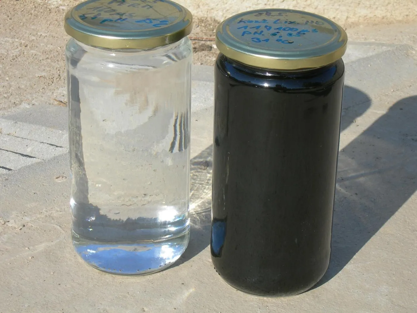 Two glass jars side by side: dark landfill leachate and clear permeate