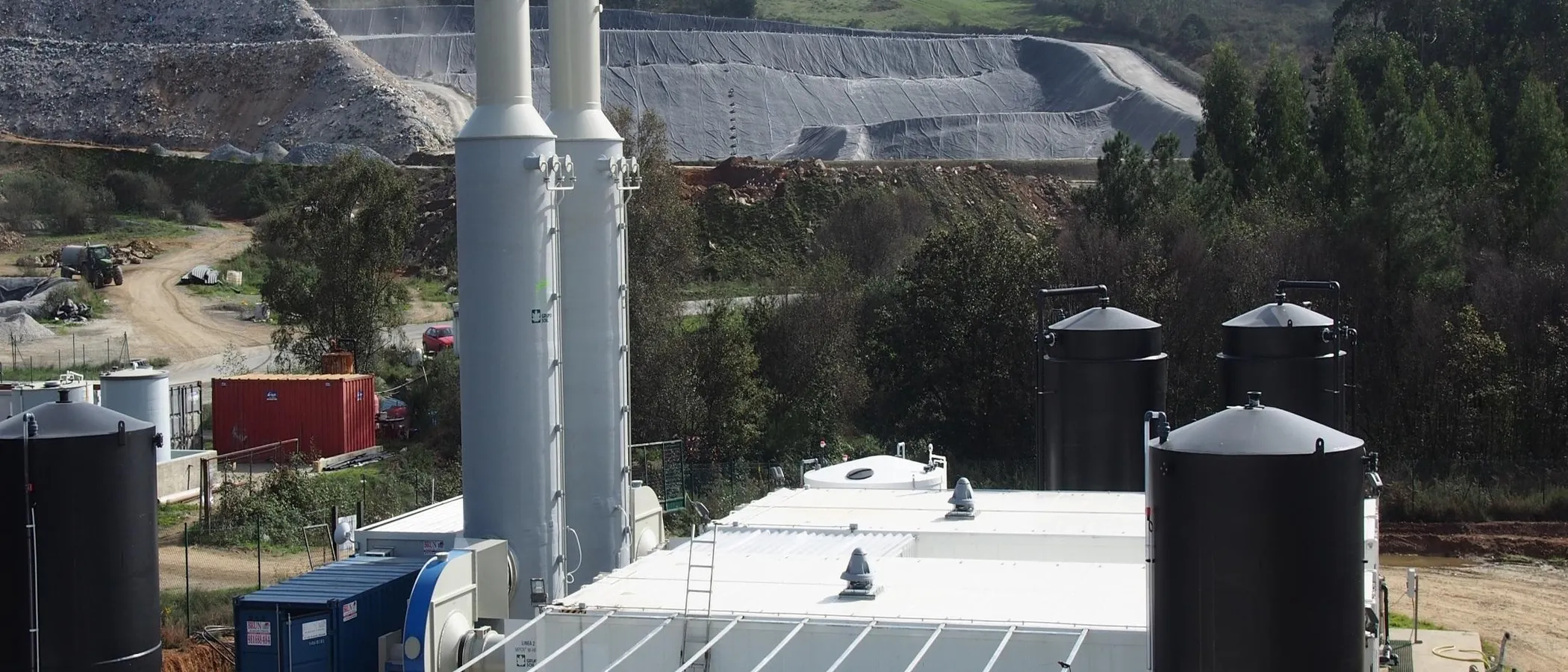 Luftaufnahme der Sickerwasseranlage in Galicien mit Kolonnen und Tanks vor dem abgedichteten Deponiekörper