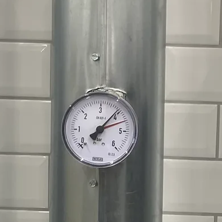 Close-up of a pressure gauge on an insulated water line